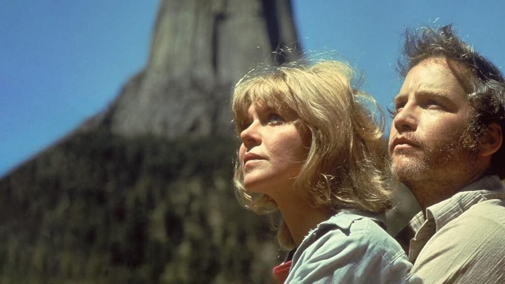Dois personagens de Contatos Imediatos do Terceiro Grau observam o céu diante da formação rochosa da Torre do Diabo.