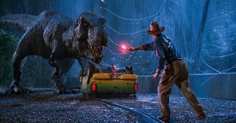 T. rex encara Alan Grant sob forte chuva enquanto ele segura um sinalizador vermelho diante de um veículo de Jurassic Park.